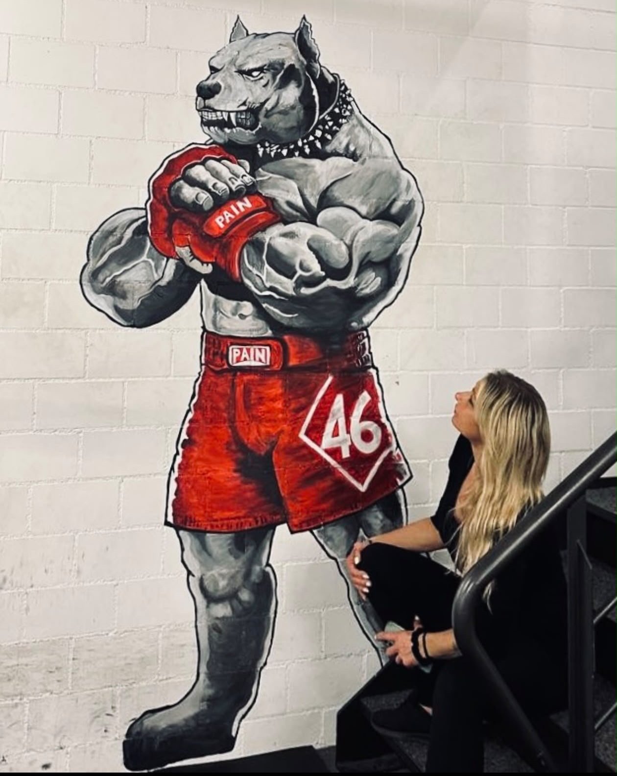 Diana next to her hand-painted boxing pit bull mural